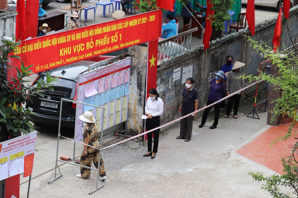 Người dân tại khu cách ly phường Cao Xanh, TP Hạ Long thực hiện nghiêm việc giãn cách theo đúng quy định khi bỏ phiếu bầu cử.